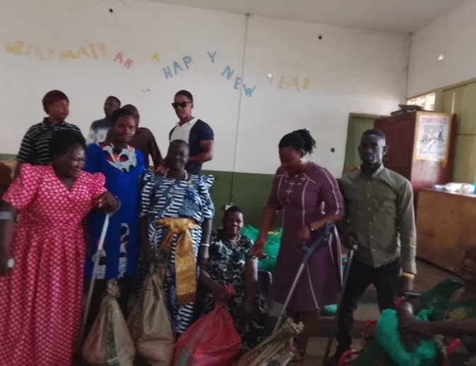 Women members of KPDDI, several using crutches, standing together in the community hall
